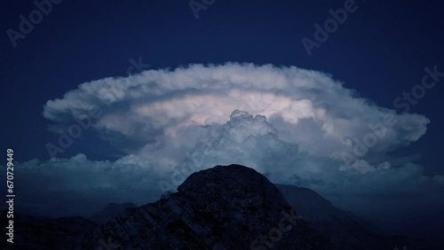avvicinamento alla nube temporalesca con fulmini sulle cime delle montagne photo