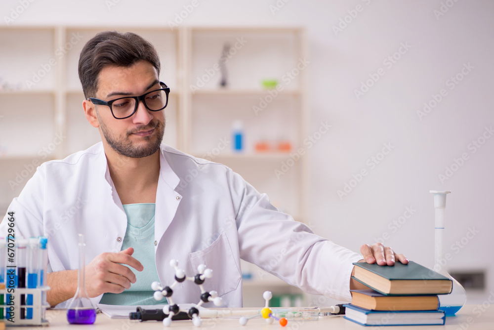Young male chemist sitting at the lab Young male chemist sitting at the lab