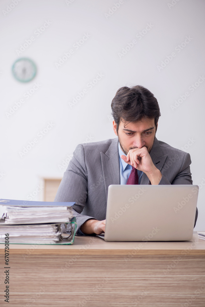 Young male employee sitting in the office Young male employee sitting in the office