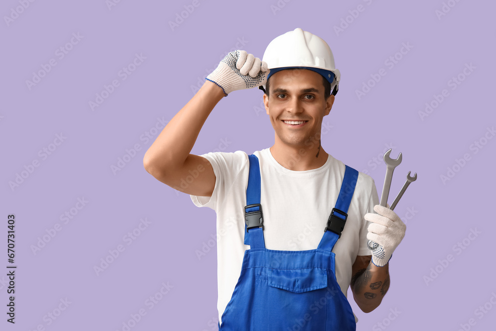 Male car mechanic with wrenches on lilac background Male car mechanic with wrenches on lilac background
