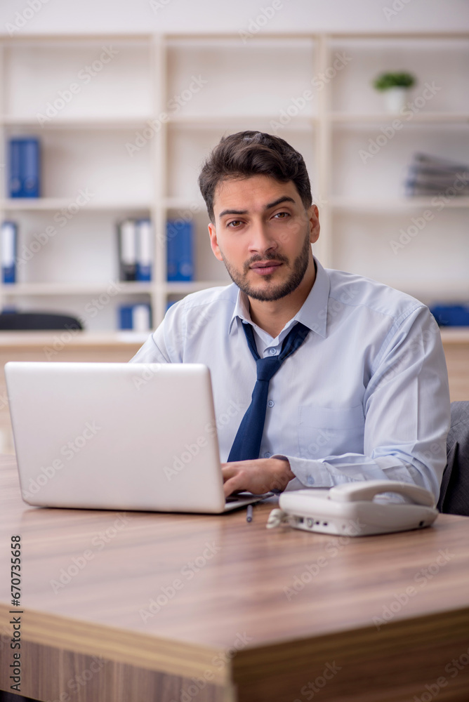 Young male employee and too much work in the office Young male employee and too much work in the office
