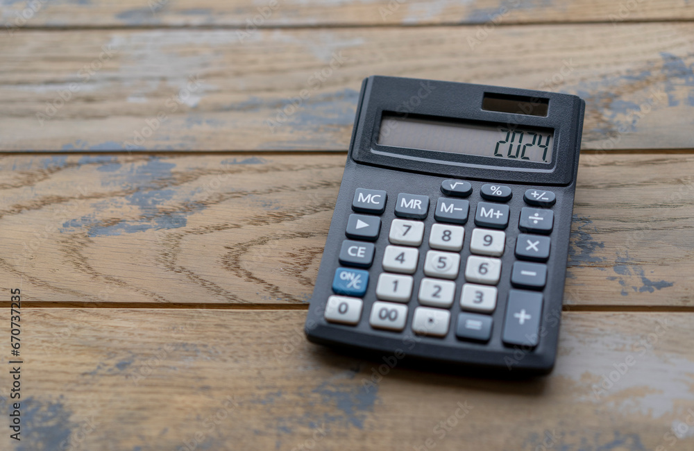 Calculator with the number 2024 on the display. Concept of finance, taxes, savings and economic crisis.
