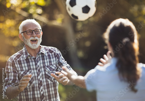 Nurse and senior man playing football in park