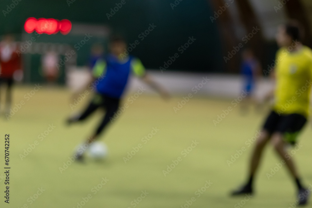Five-a-side soccer players playing game in indoor stadium on artificial turf. Five-a-side soccer players playing game in indoor stadium on artificial turf.