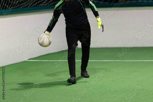 Ball in hands of arena soccer goalkeeper.
