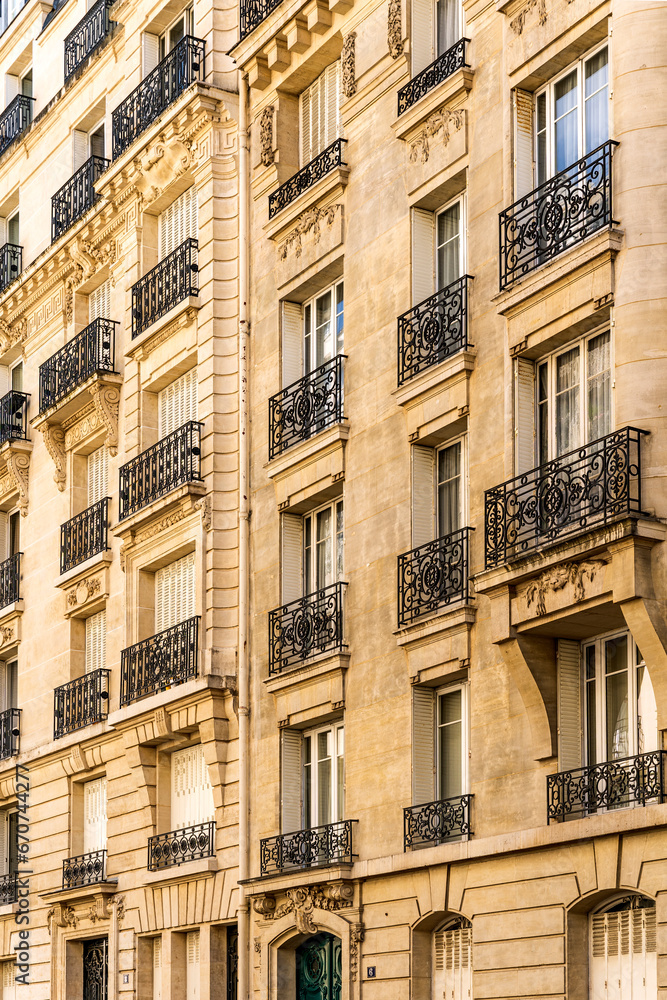 Façade of a typical and elegant residential building in Passy quarter, in Paris, France, with wrought iron railings and balconies Façade of a typical and elegant residential building in Passy quarter, in Paris, France, with wrought iron railings and balconies