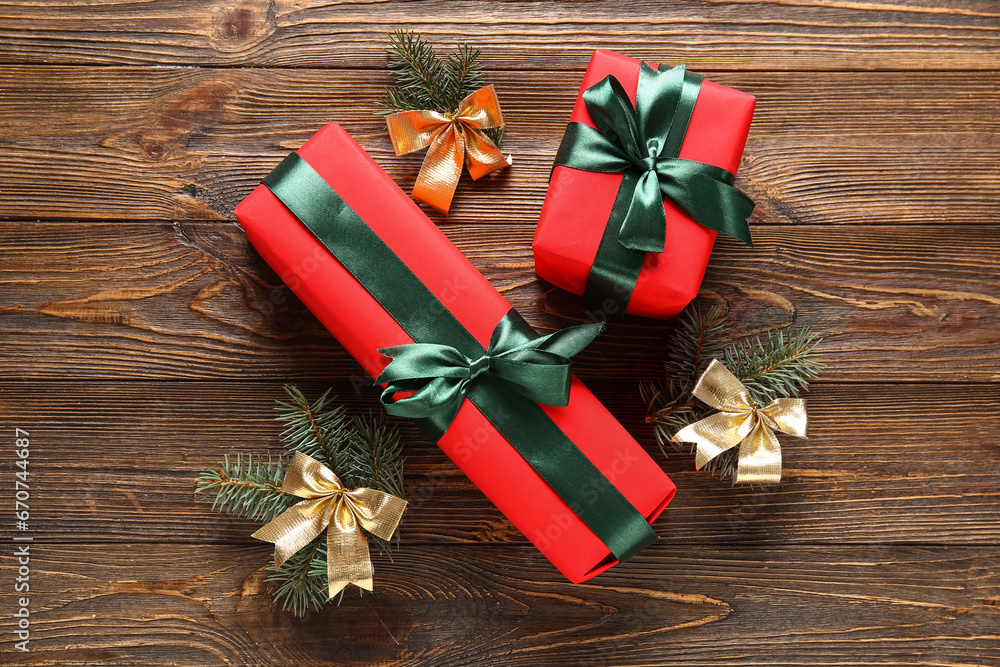 Gift boxes with Christmas tree branches and bows on wooden background Gift boxes with Christmas tree branches and bows on wooden background
