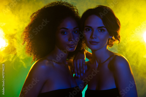 Photo of two tender girls best friends enjoy weekends in modern nightclub with shine mist neon lights