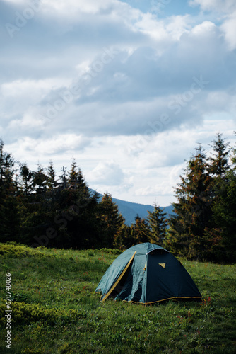 Tourism and traveling concept. Beautiful summer landscape with mountain forest and tourist tent. © luengo_ua