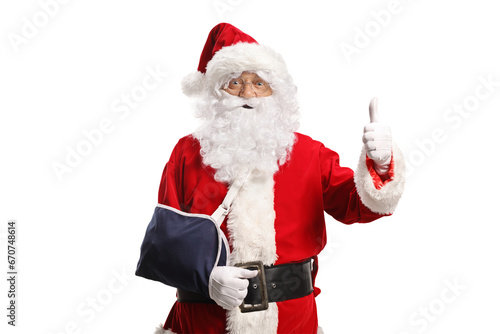 Santa Claus with an arm injury wearing a sling and gesturing thumbs up © Ljupco Smokovski