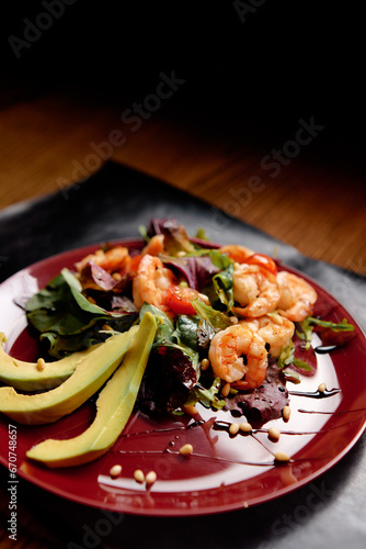 Salad with avokado and shrimps on a wooden table. Healthy food.