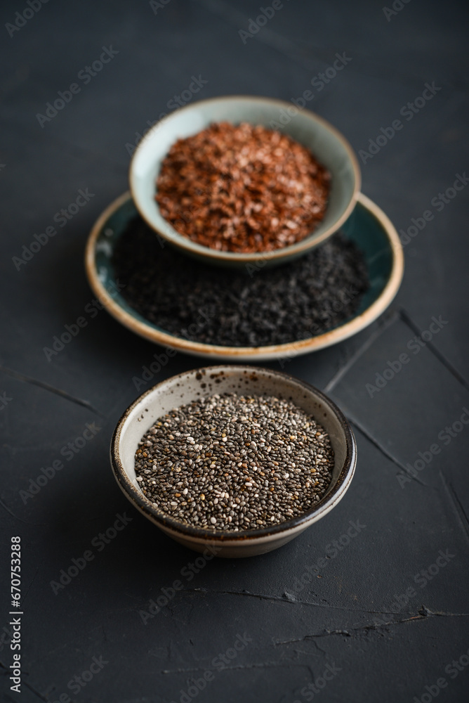 Black sesame, flax and chia seeds in ceramic plates Black sesame, flax and chia seeds in ceramic plates