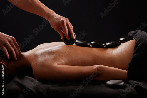 A man receives a hot stone massage, a masseur gives a stone massage photo