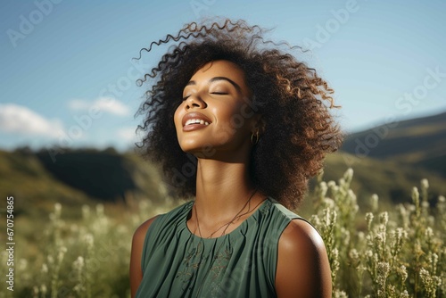 Young afro woman breathing fresh air on mountain