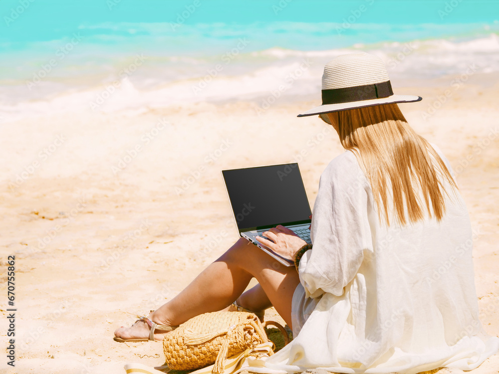 young woman uses laptop computer on the beach. distance work, freelancer and blogger concept. WiFi unlimited