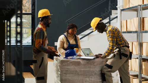 фотографія Manager catching employees wasting time in warehouse, team of people talking and laughing instead of packing products in boxes for distribution