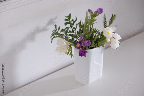 vase with white and purple flowers on the table
