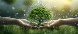 Human hand holding green tree on nature background.