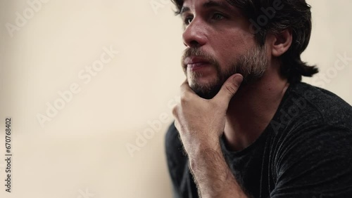 Preoccupied young man with pensive expression. Stressed worried male person in 30s closeup face