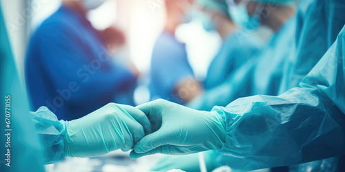Wide view of surgeons surgical gloves with medical staff blurred in the background photo