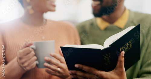 Closeup, hands and a couple reading the bible together in the morning for spiritual wellness. House, support and a man and woman with coffee, talking and a book for religion education and studying