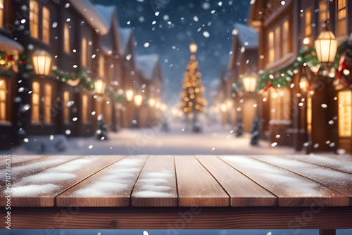 Empty wooden table top with blurry Christmas town and snowfall background. A lit Christmas tree is present in the decorated town square. Celebrate the Christmas holidays. Christmas holiday background