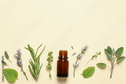 Bottle of essential oil and different herbs on beige background, flat lay. Space for text