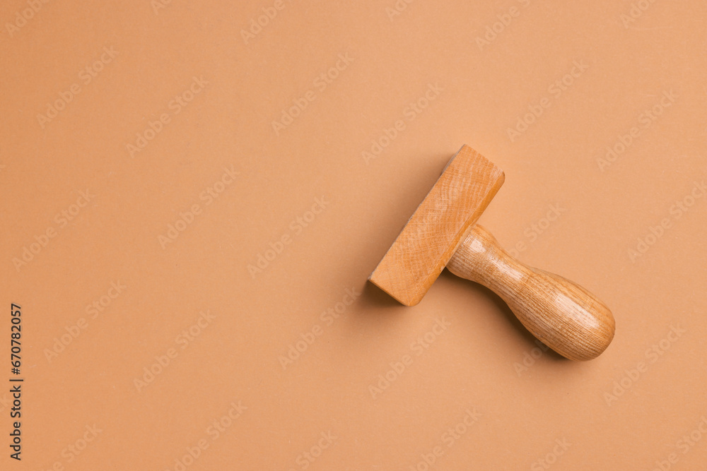 One wooden stamp tool on light brown background, top view. Space for text