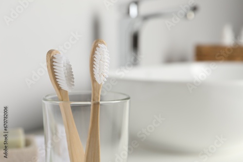 Bamboo toothbrushes on blurred background, closeup. Space for text