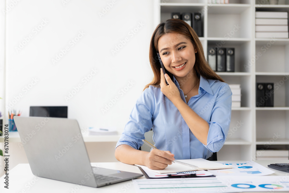 Cheerful businesswoman working with laptop, female office worker smiling charmingly. Work with financial documents to analyze company financial data. Cheerful businesswoman working with laptop, female office worker smiling charmingly. Work with financial documents to analyze company financial data.