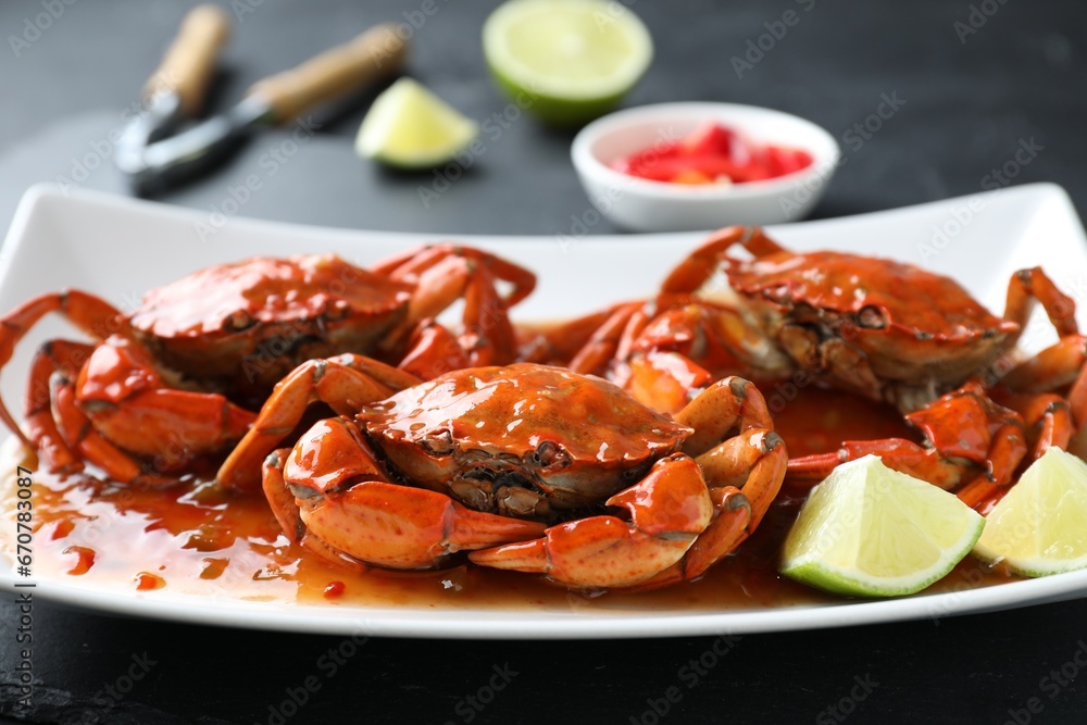 Delicious boiled crabs with sauce and lime on black table, closeup Delicious boiled crabs with sauce and lime on black table, closeup