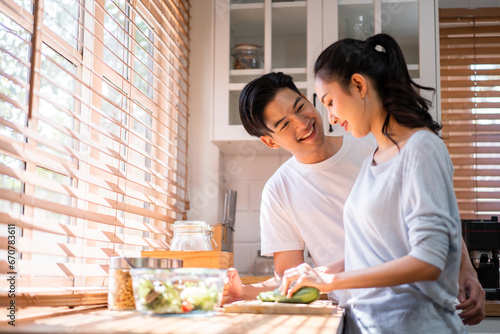 Asian young new marriage couple spend time together in kitchen at home. 