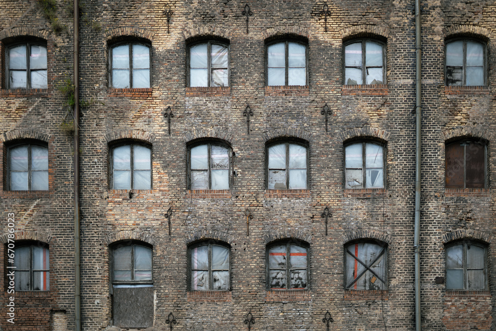 Facade of an old abondoned building boarded up windows , old brick building