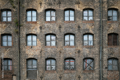 Facade of an old abondoned building boarded up windows , old brick building