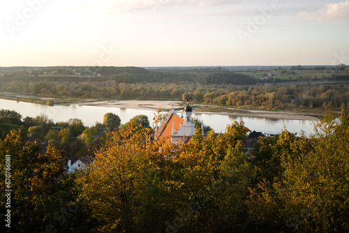 Sunset Rural autumn Polish scenery with church, forest and river. Polish countryside scenery