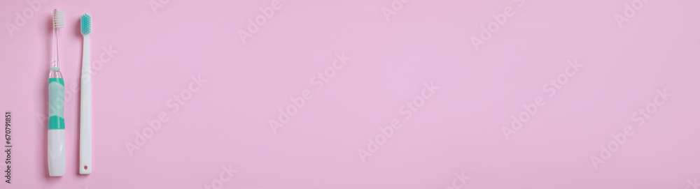 Electric and plastic toothbrushes on pink background, top view. Banner design with space for text Electric and plastic toothbrushes on pink background, top view. Banner design with space for text