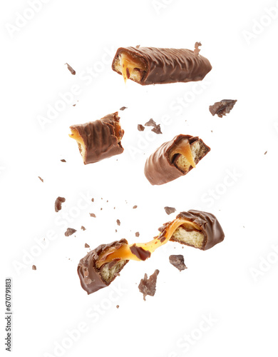 Pieces of chocolate bars with caramel falling on white background