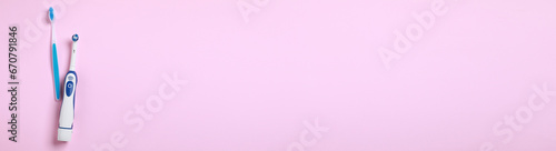Electric and plastic toothbrushes on pink background, top view. Banner design with space for text
