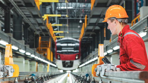 Electric train technician engineer checking controls system for security functions in maintenance infrastructure plant of sky train, public transportation vehicle,Teamwork management concept.