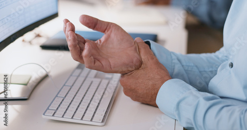 Businessman, hands and wrist in joint pain from injury, overworked or carpal tunnel syndrome at office. Closeup of man or employee with arthritis, ache or inflammation of palm on desk at workplace photo