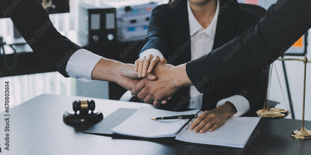 Businessman shaking hands to seal a deal with his partner lawyers or attorneys discussing a contract agreement Businessman shaking hands to seal a deal with his partner lawyers or attorneys discussing a contract agreement