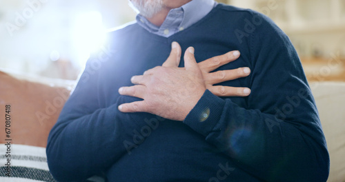 Φωτογραφία Hands, chest and heart attack with a senior man closeup on a sofa in the living room of his home during retirement
