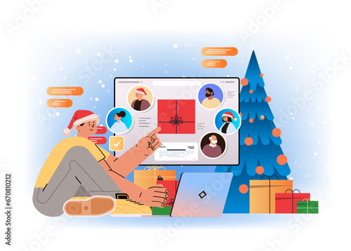 man in santa hat chatting with mix race friends on laptop screen near decorated christmas tree and gift boxes social media communication