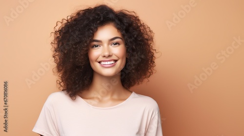 Portrait of a cheerful young woman wearing pink shirt standing isolated over pink background, looking at camera, posing