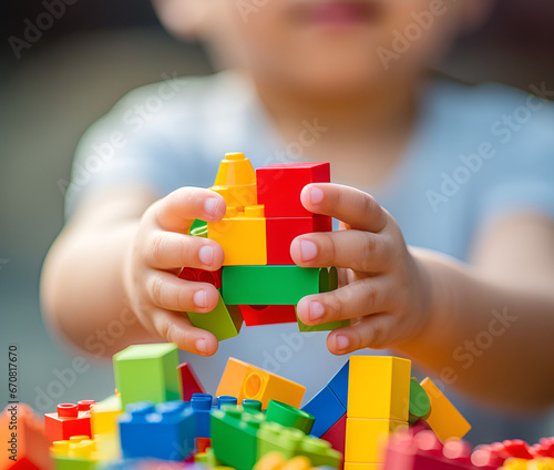 Close-up photograph of a little kid's hands as joyfully plays with a colorful set of building blocks
