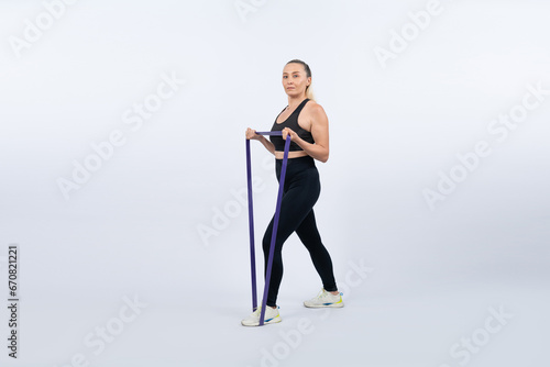 Full body length shot athletic and sporty senior woman with fitness resistance band on isolated background. Healthy active physique and body care lifestyle after retirement. Clout © Summit Art Creations