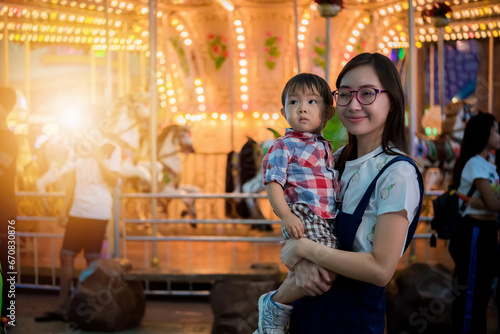 Portrait of happy mother and baby boy in amusement park night