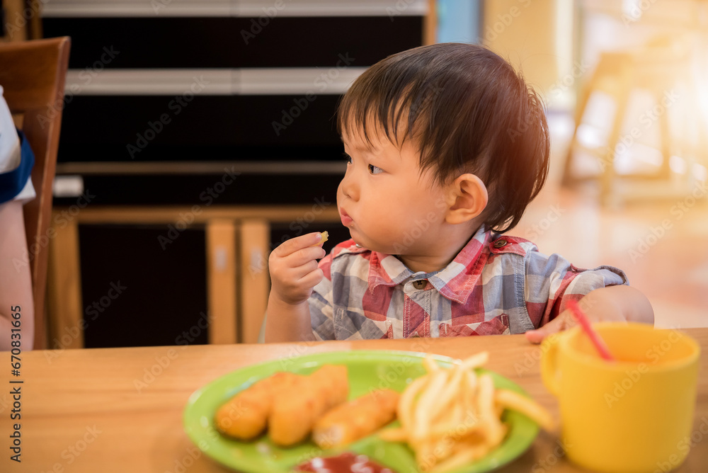 Asian baby eating food at restaurant