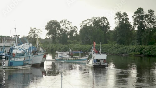 Handheld shot of small boats sailing on Caete River, Braganca, Pará, Brazil photo