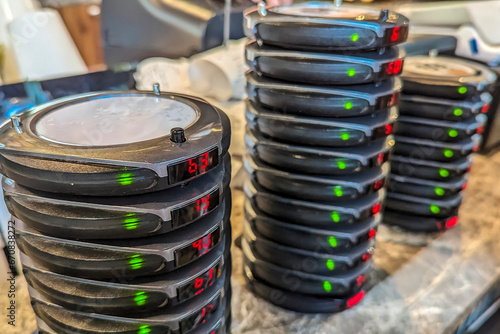Stacks of wireless restaurant pager, buzzers or beepers at the counter of a cafe. An Electronic Restaurant Guest Paging System. photo